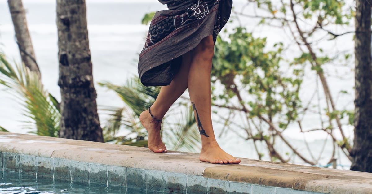 Crossing Swiss-Austrian border by foot - Unrecognizable woman walking along poolside in tropical resort