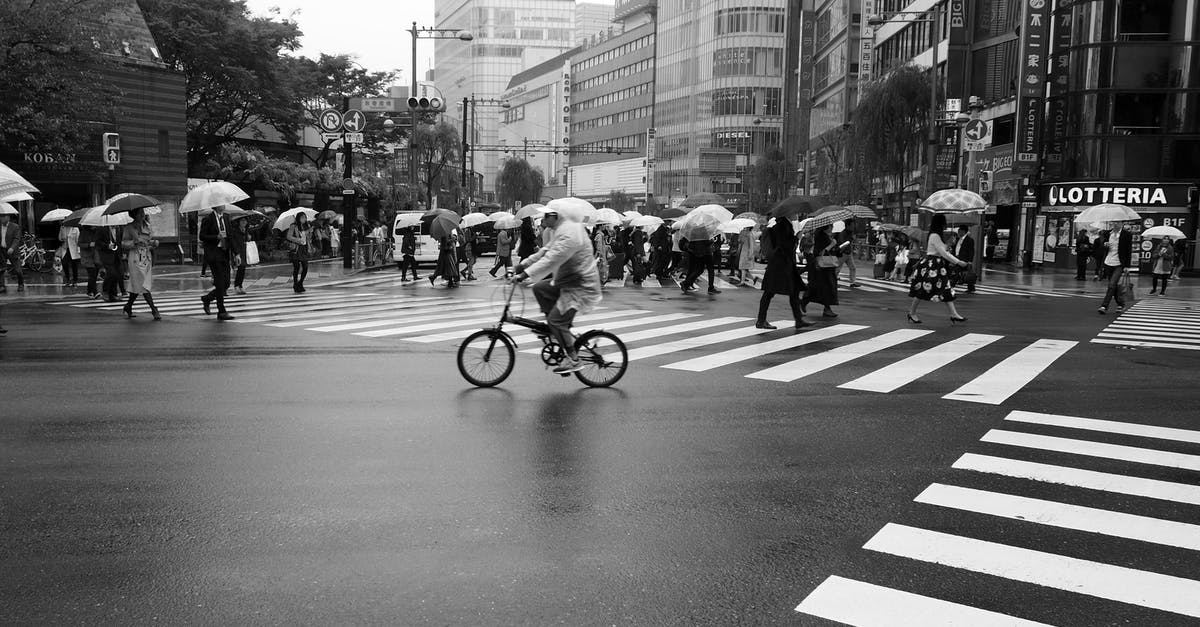 Crossing the Canadian border with all your camping/mountaineering/mountain biking gear? - Grayscale Photo of People Crossing the Street on a Rainy Day