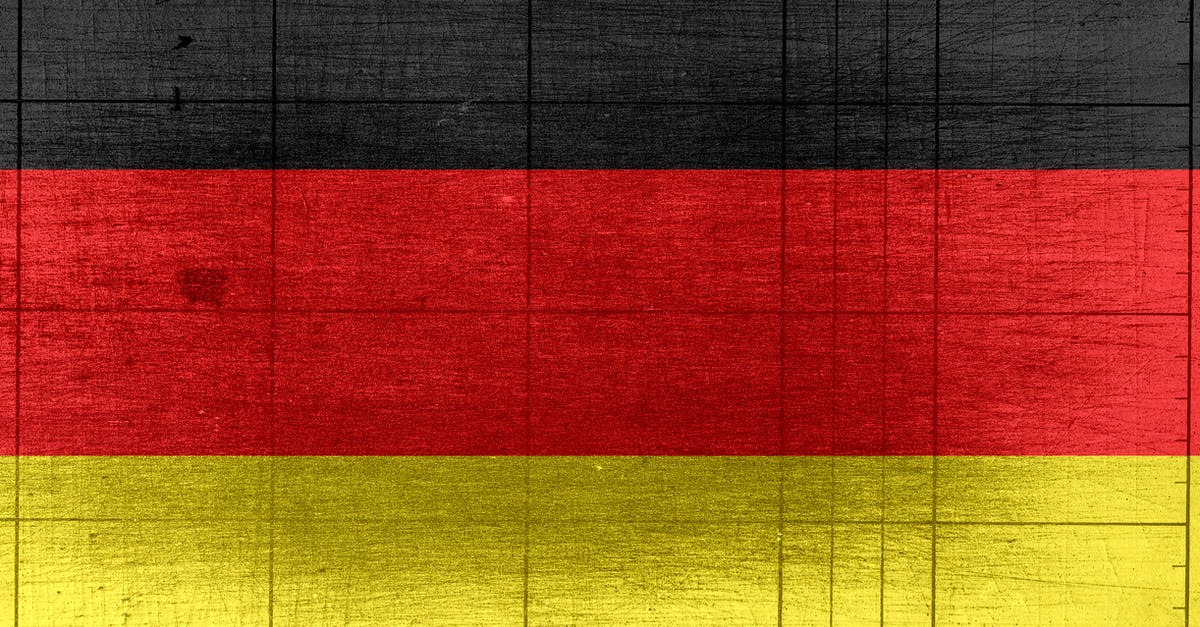 Crossing the German border as an underage travelling alone - Grungy background designed as flag of Germany on shabby wooden board with measure scale