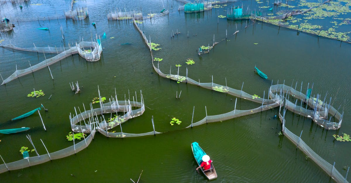 Crossing the Skadar Lake by boat or bicycle - A Person Riding a Boat on a Fish Farm