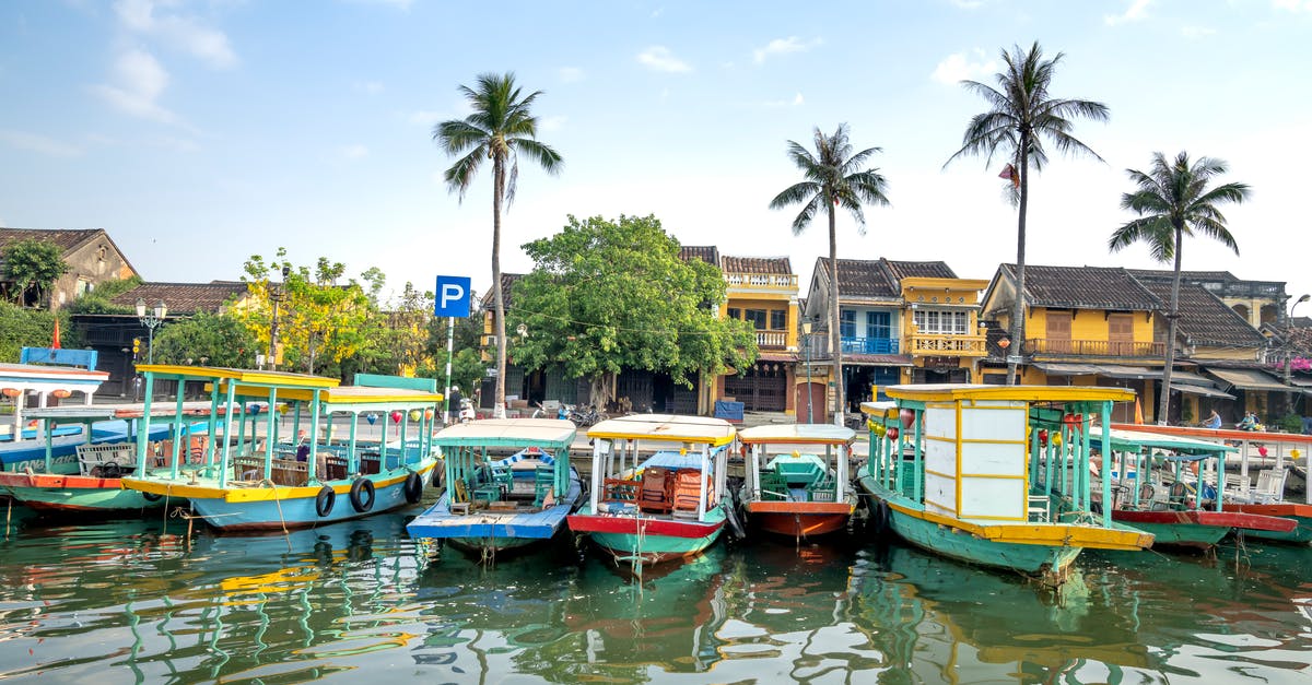 Cruising to Vietnam - Cruise boats moored on river in tropical village