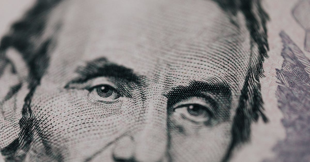 Currency exchange (USD to NTD and HKD) in San Francisco - Closeup of male American president printed on five dollar bill and looking away pensively