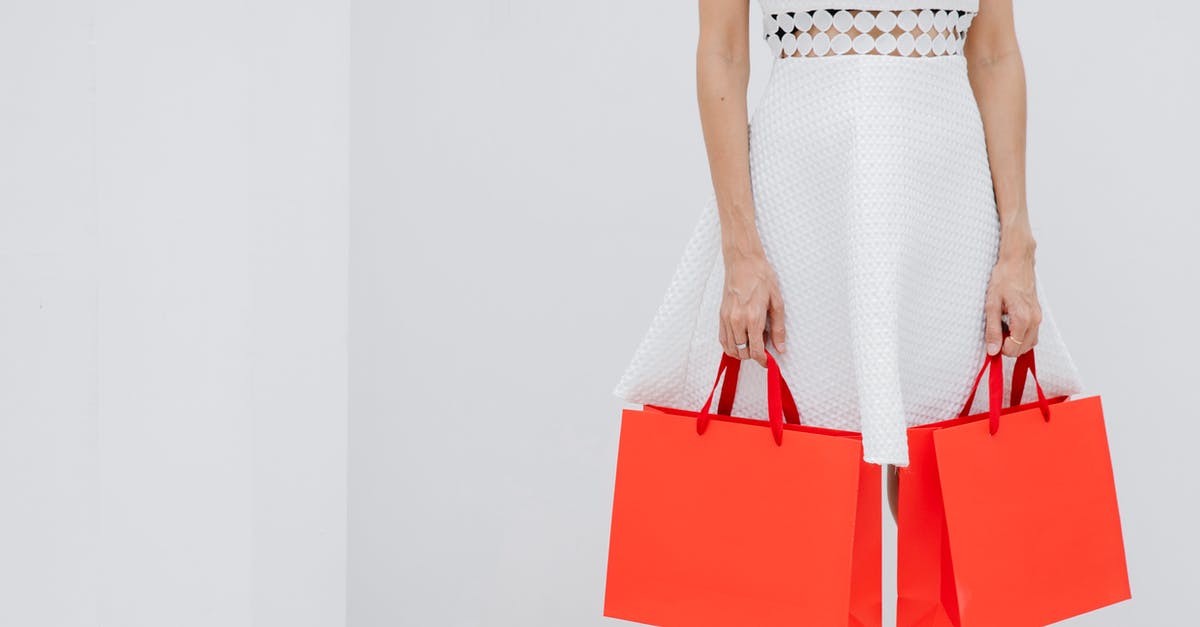 Customs and immigration clearance transiting at DEL - Crop unrecognizable woman carrying red shopping bags in studio