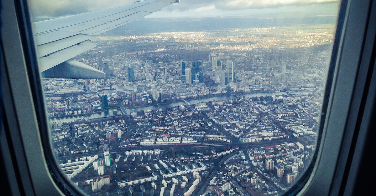 Cutting pain under eyebrow on plane landing - Airplane Windowpane Showing City Buildings