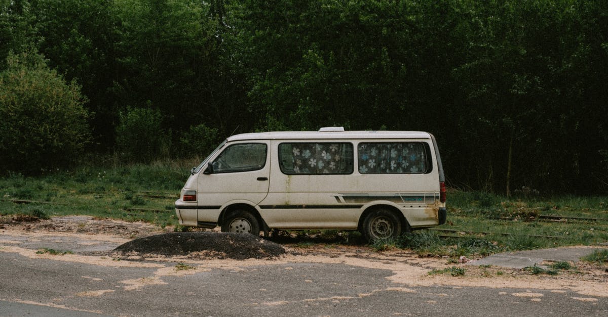 Damaged luggage compensation - White Van Parked on Dirt Road Near Green Trees