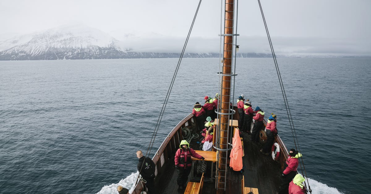 Day Tours from Within Kazbegi / Stepantsminda [closed] - From above of unrecognizable people in similar outerwear standing on modern sailboat and admiring sea and mountains in winter day