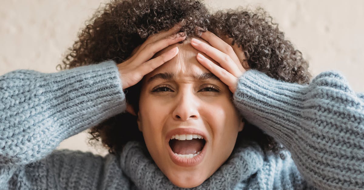 Dealing with aggressive touts in markets? - Expressive African American woman with curly brown hair touching head and yelling against light background