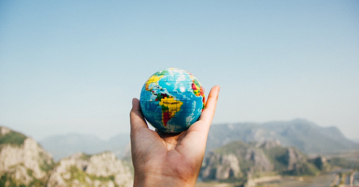 Dealing with the 'unclean hand' when travelling (if you're left-handed) - Person Holding World Globe Facing Mountain