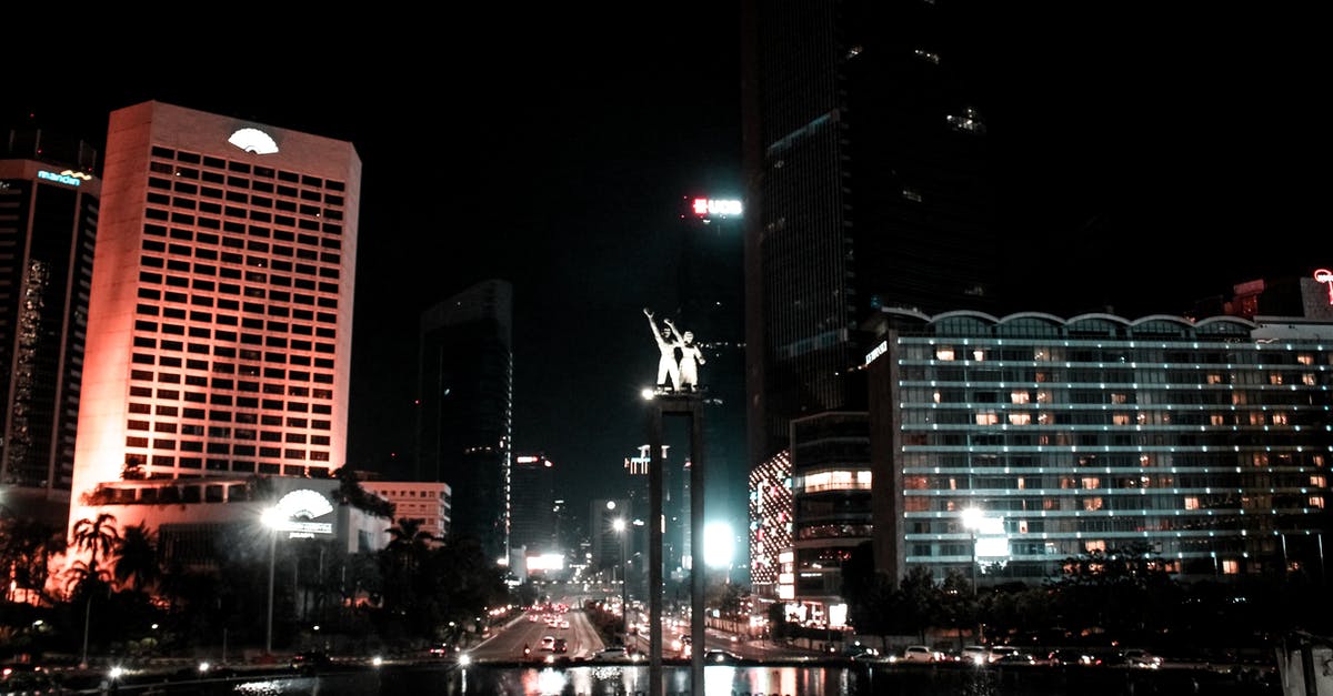 Definition of "first embarkation point" for trip to Indonesia - From below of illuminated Selamat Datang Monument located in downtown of Jakarta near modern buildings at night