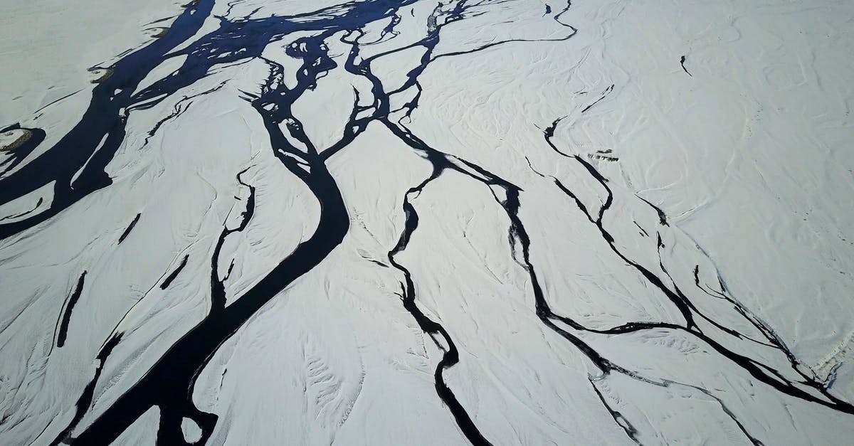 Delta TSA-Precheck status removed - Drone view of snow covered terrain with picturesque glacial river system in winter