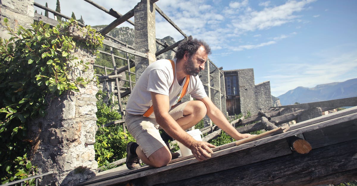 Denial of Entry or Travel Ban in Schengen area - Focused man building roof of wooden construction