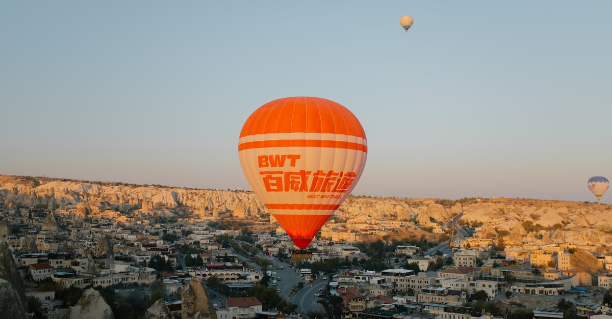 Denied boarding by Ryan Air even though my passport is visa-free to the destination - Orange hot air large balloon landing in old eastern town on summer evening