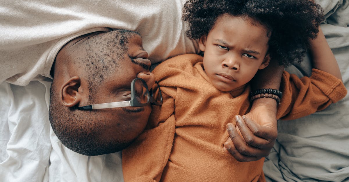 Dependent children deported from in UK visa form [closed] - Top view of African American man in glasses lying near angry child in casual clothes while cuddling together in comfortable bedroom