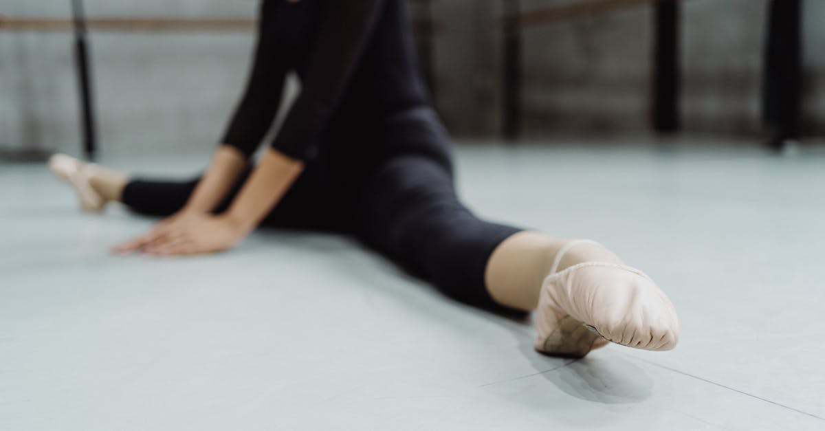 Determine Cathay Pacific fare class - Faceless ballerina warming up during dance rehearsal and stretching muscles of legs in ballet hall