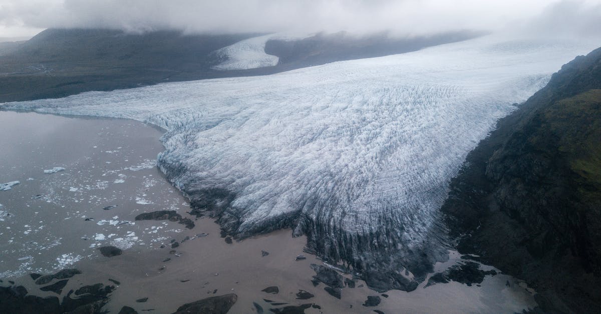 Deutsche Bahn - Quer-durchs-Land-Ticket and ICE - Majestic glacier tongue reaching seashore under gloomy misty sky