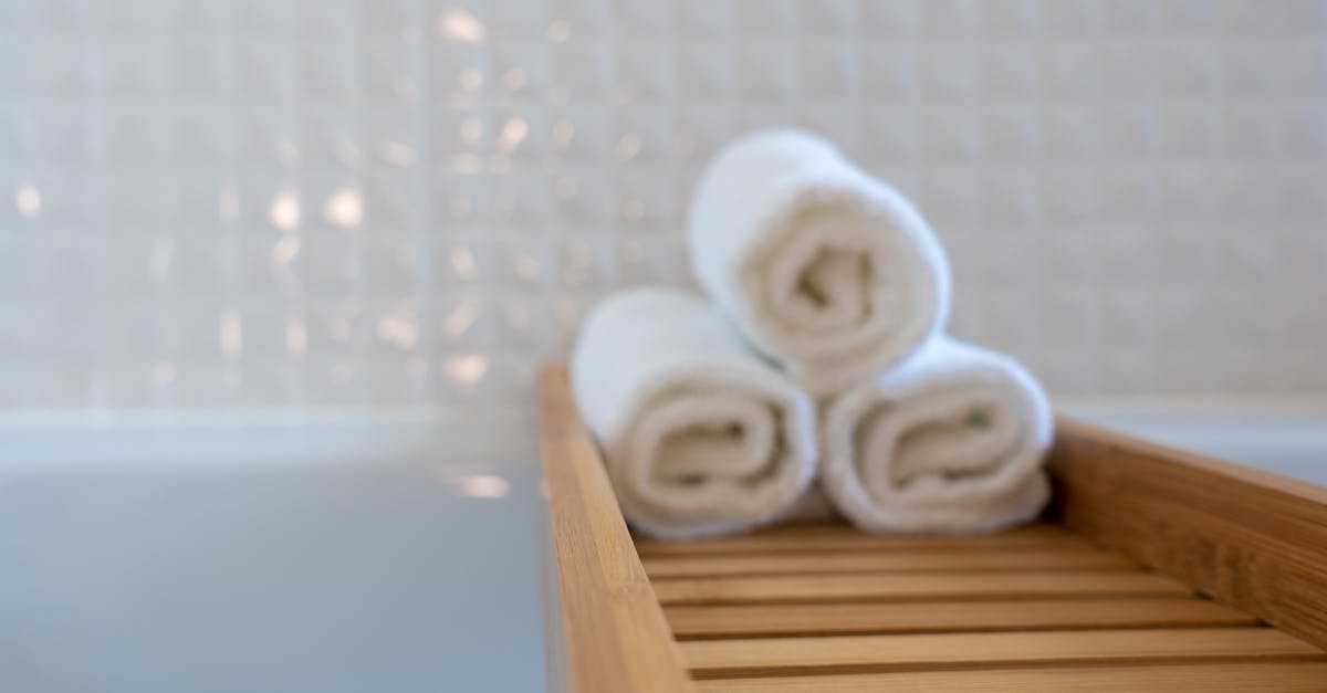 Dial knob in hotel bathroom - Three Towels on Brown Wooden Rack