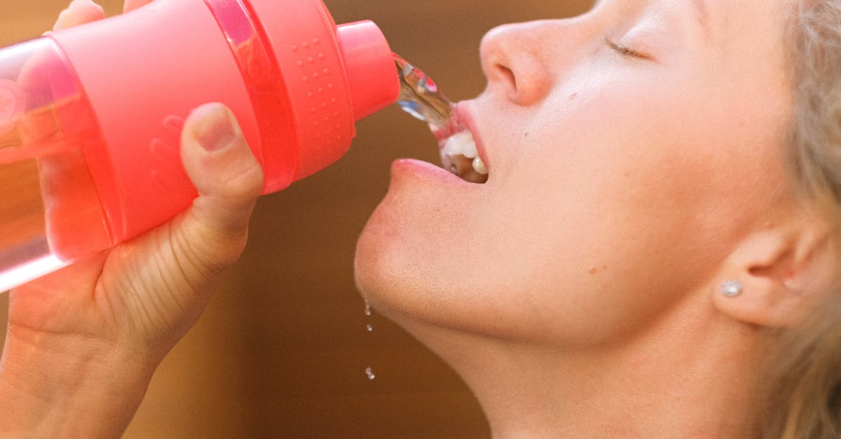 Difference in mineral bottled water price between European countries [closed] - Crop tired young female pouring refreshing clean water into mouth from reusable bottle after intense training