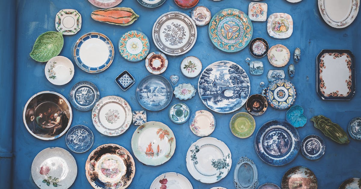 Different Details on Previous Passport - Composition of various decorative ornamental plates of different sizes and colors arranged on blue wall