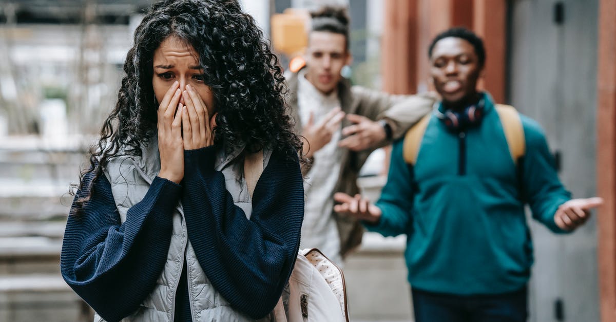 Difficult situation with german student visa [closed] - Sad ethnic woman crying after being bullied by multiracial male students