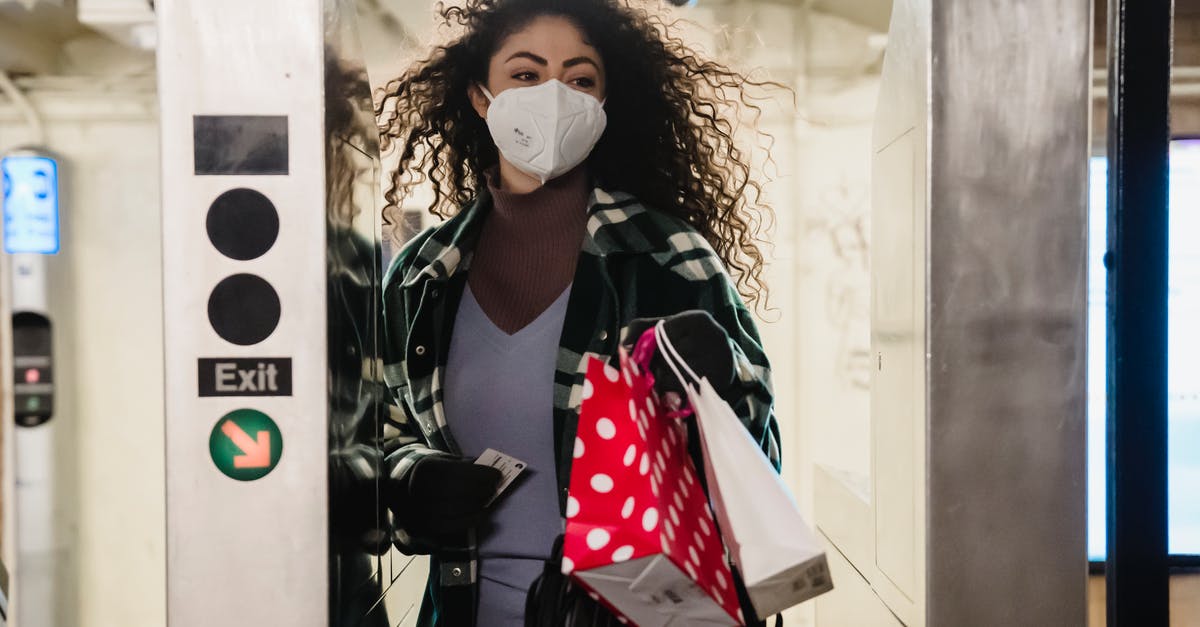 Difficulties with or reprimands for passing COVID hotspot? - Woman walking through turnstile in subway