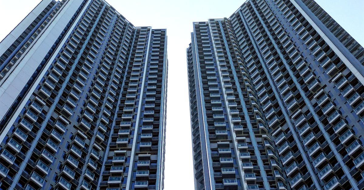 Do airlines block out a large section of seats online? - From below of similar contemporary high rise residential buildings with balconies under blue sky