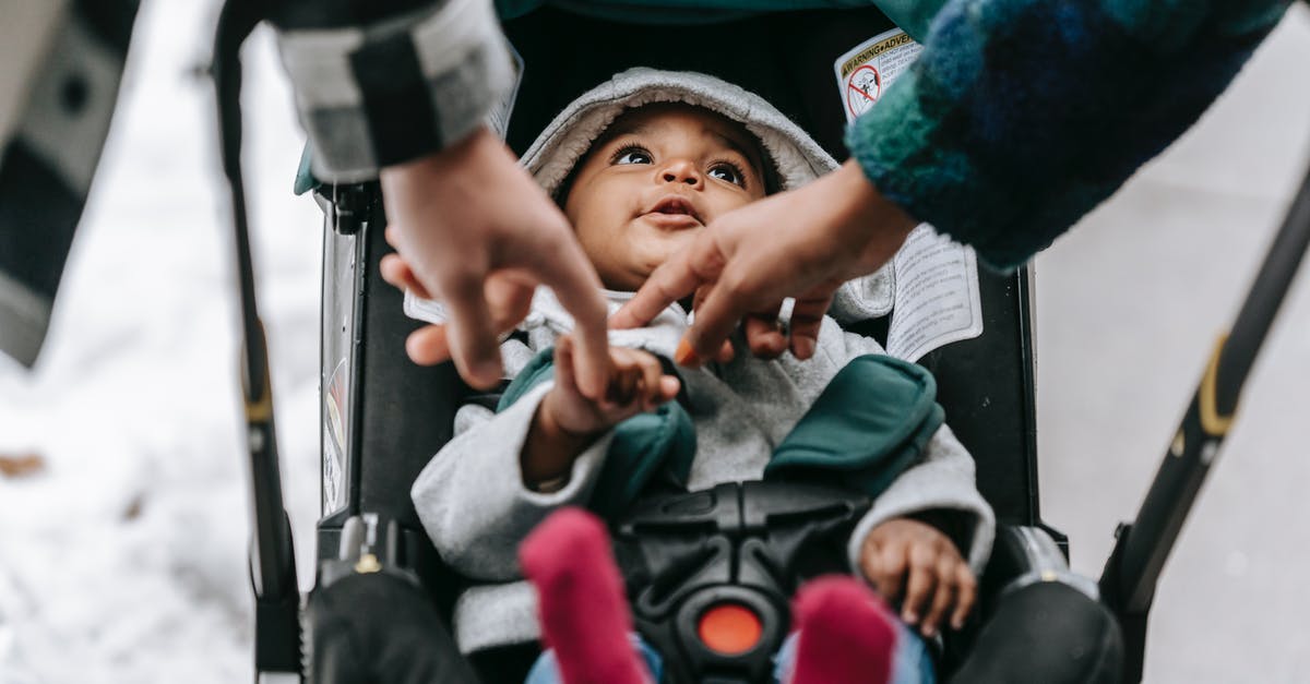 Do airlines count child carriers / baby backpacks as strollers? - Crop parents with black baby in carriage