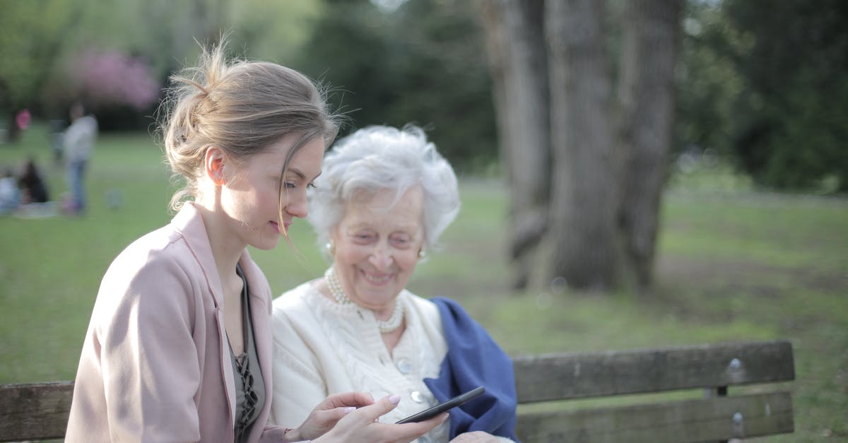 Do all GPS devices support all major regions? - Side view of smiling adult female helping aged mom in using of mobile phone while sitting together in park