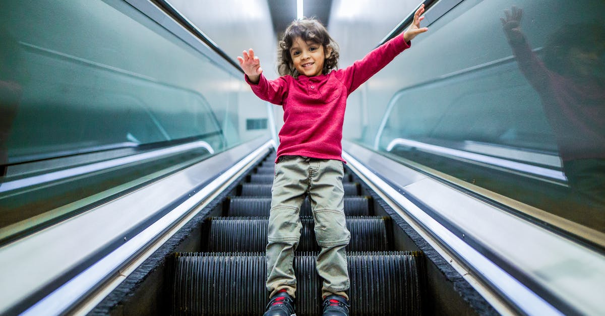 Do any airlines have bans on children from certain passenger sections? - Positive boy standing on escalator