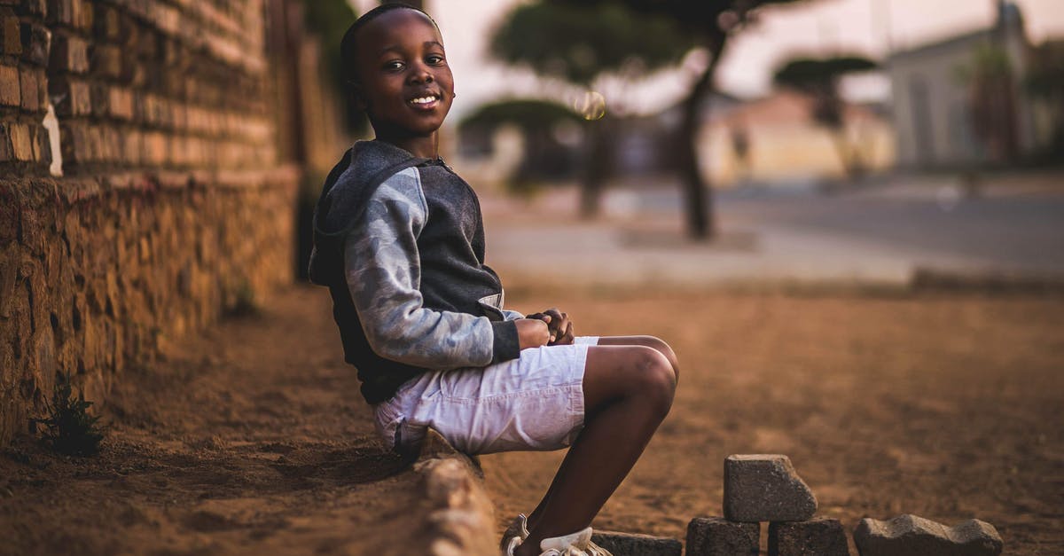 Do children stay free in hotels/accommodation in South Africa? - Boy Sitting on Dirt