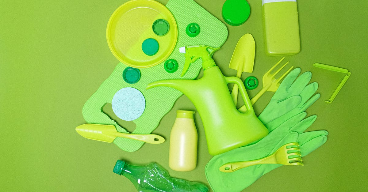 Do different language editions of Lonely Planet contain different content? - Top view monochrome of various plastic bottles and kitchen utensil polluting planet on green background