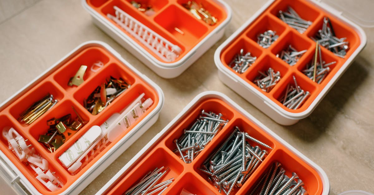 Do different language editions of Lonely Planet contain different content? - From above of boxes with different metal nails and plastic dowels in workshop