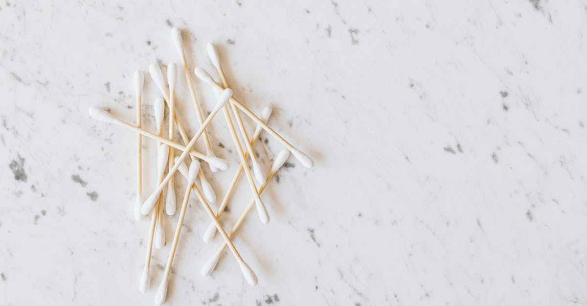 Do ear wax cleaning salons provide related, similar services? - From above of heap of similar cotton swabs on thin wooden sticks with soft edges on marble surface with grey lines