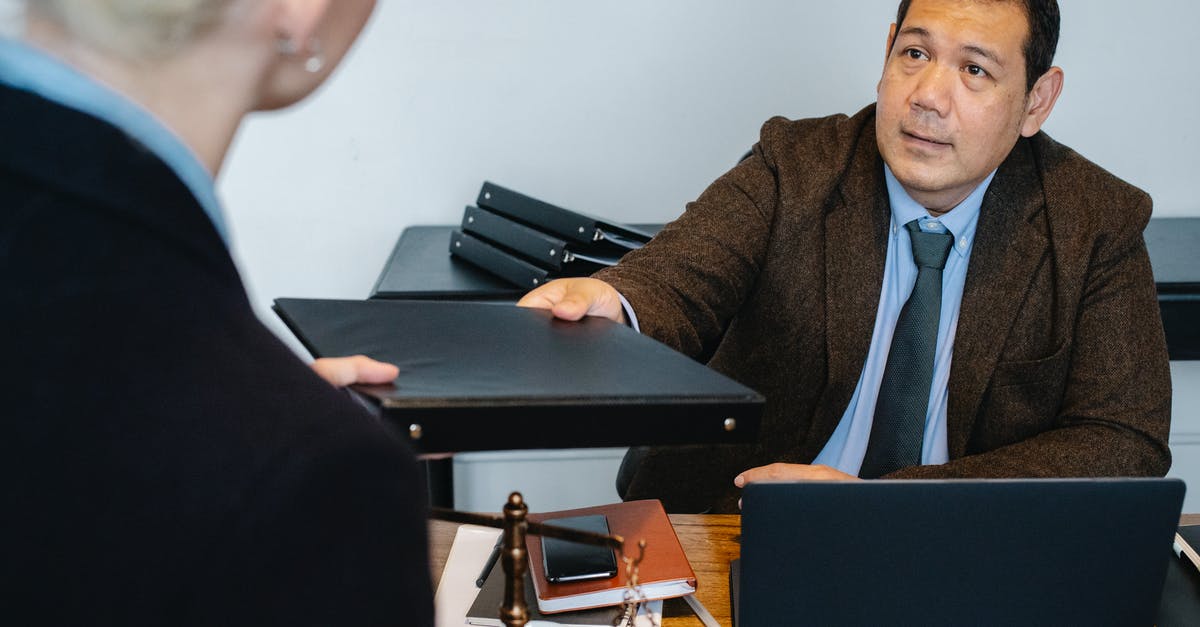 Do embassies give you your documents back? - Concentrated ethnic businessman giving folder to female employee in workplace