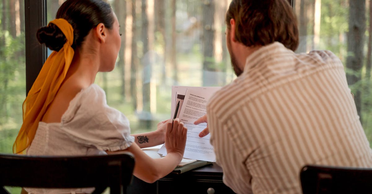 Do embassies give you your documents back? - Man and Woman Looking at Papers