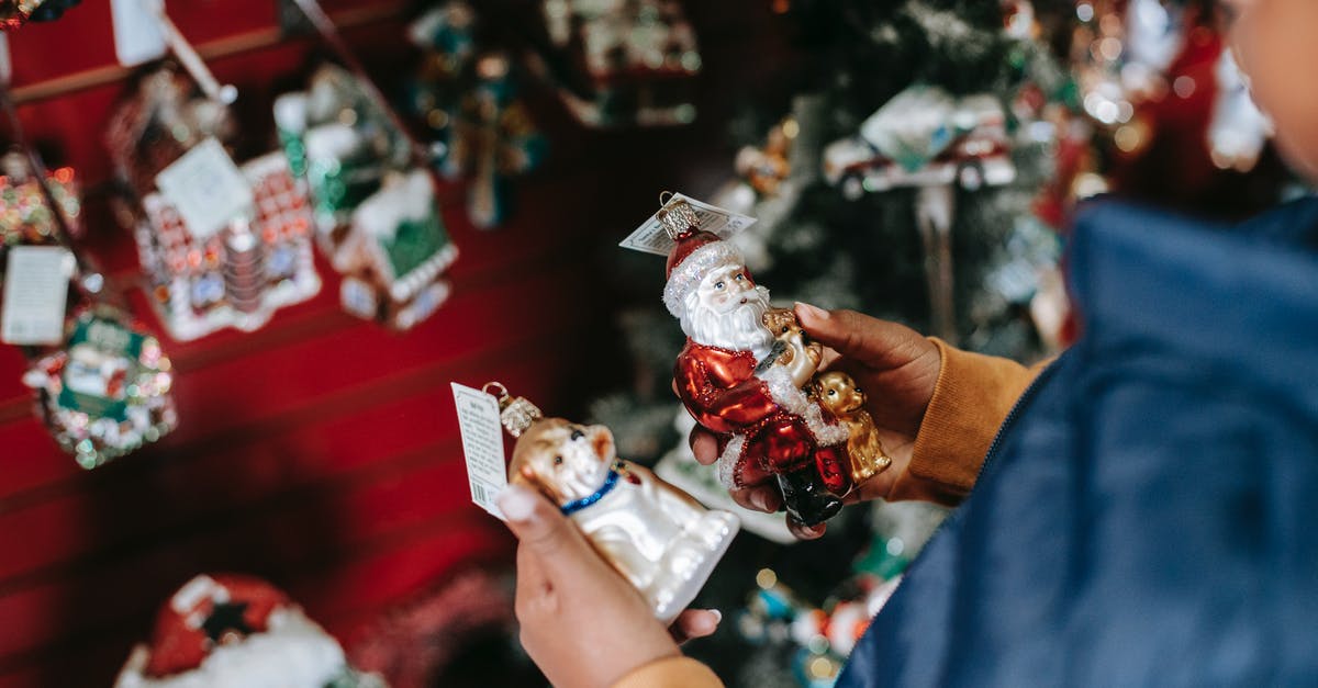 Do German shopping malls offer staffed children playrooms? - Side view of crop ethnic girl with Santa and dog toys standing in shop with Christmas decorations