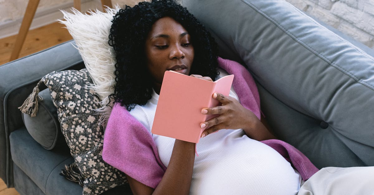 Do hotels in general expect that guests will take the toiletries provided with them? - From above of focused pregnant African American female taking notes in notepad while resting on comfortable sofa in living room