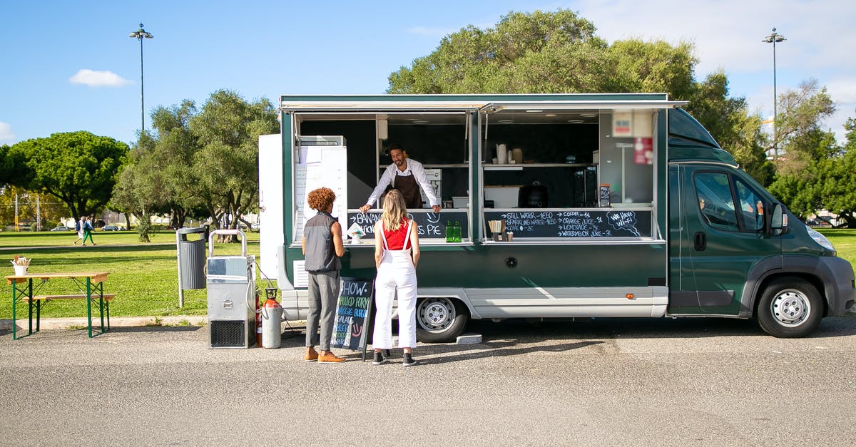 Do hotels offer "proof of stay" certificates to their guests? - Couple standing near food truck and choosing food