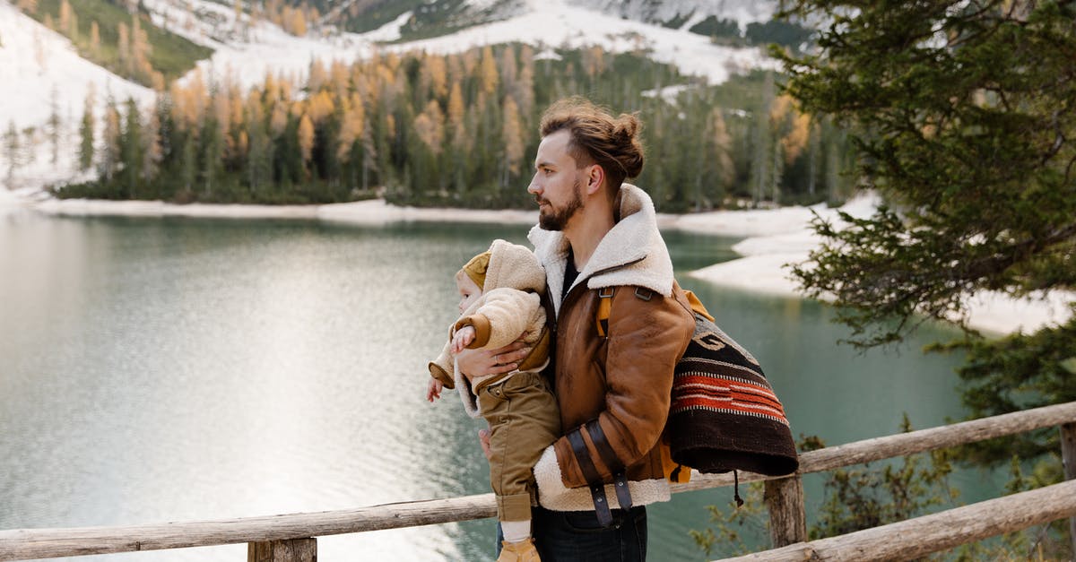 Do I have to carry snow chains in Europe? - Man in Brown Jacket Carrying His Baby