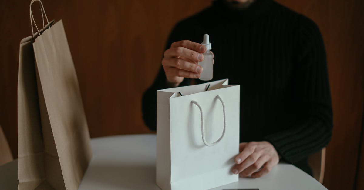 Do I have to pay double for checked baggage? - Focused man pulling out beauty product from shopping bag at table