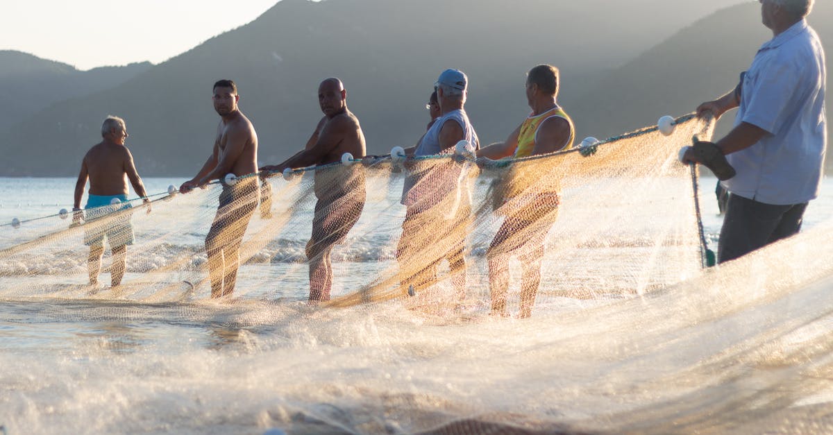 Do I need a Brazil transit visa - Men Holding A Fishing Net