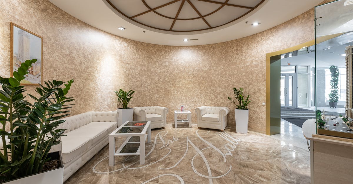 Do I need a hotel reservation when entering the Schengen area? - Interior of spacious lobby with comfortable white sofa and armchairs placed in contemporary hotel in daylight