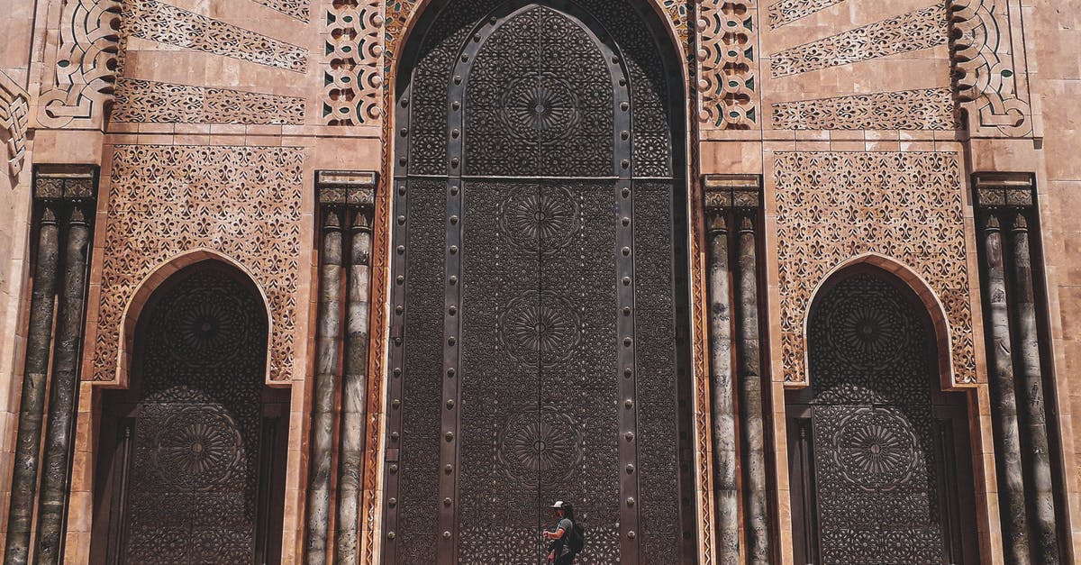 Do I need a transit visa for Morocco (Casablanca) and Guinea-Bissau for a short layover? - Side view unrecognizable person walking on piled steps of ornamental impressive mosque entrance in oriental style