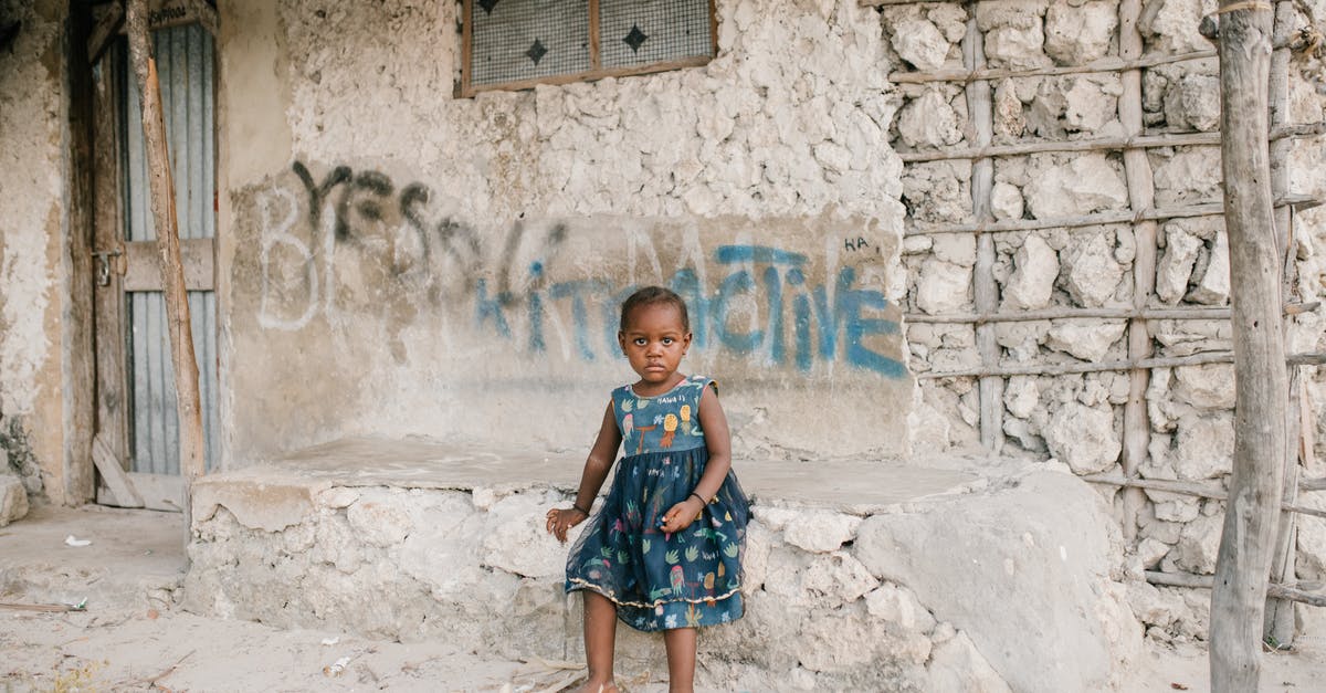 Do I need a transit-visa for a layover in Qatar? - Little black girl sitting on rough stone border in ghetto