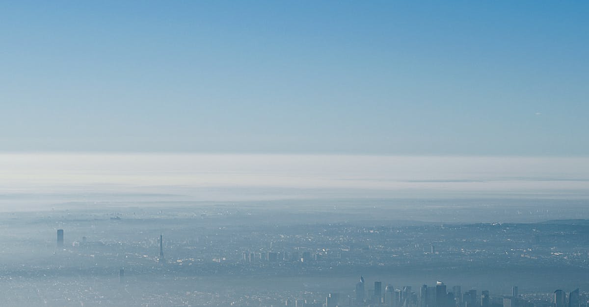 Do I need a visa to travel to Paris from London? - Breathtaking aerial view of Paris with Eiffel Tower and modern skyscrapers against blue sky