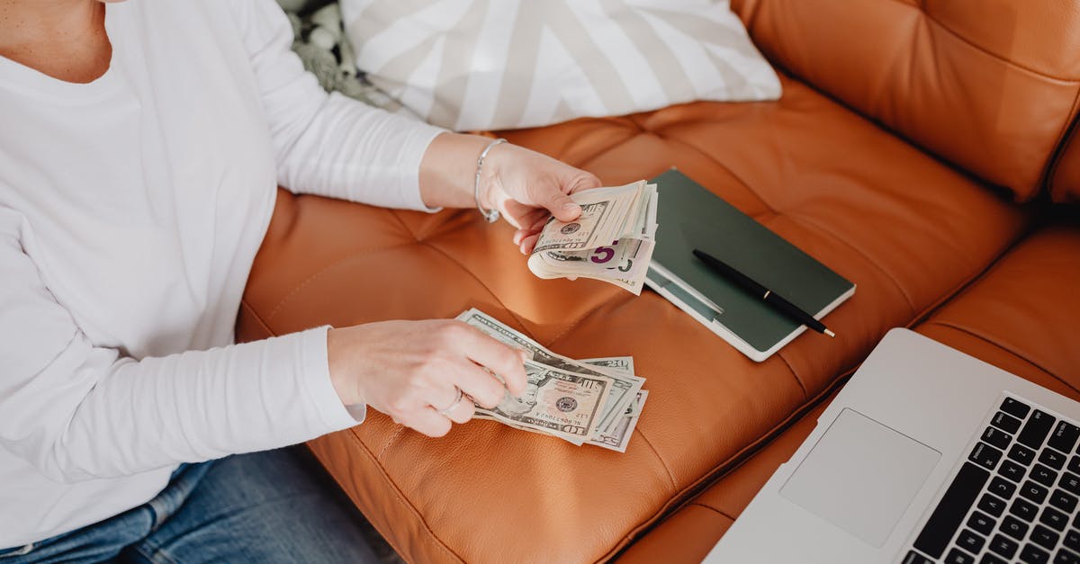 Do I need cash CHF for a weekend in Zurich? - Woman Sitting and Counting Money in front of a Laptop