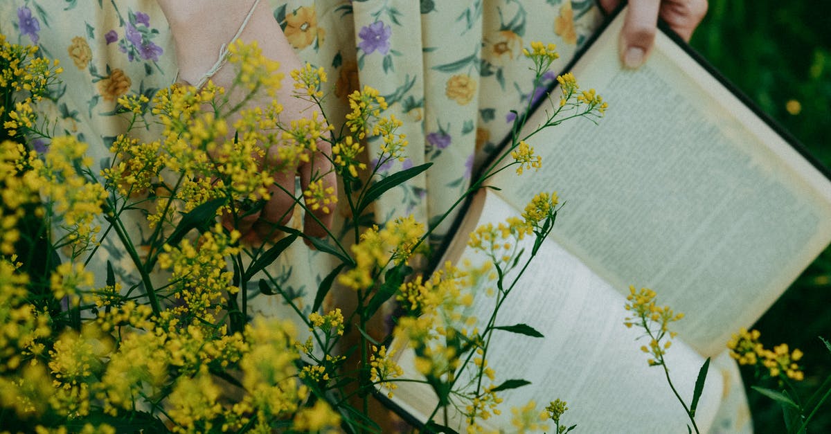 Do I need my vaccine yellow book to be physical? - Open Book in Woman Hands Behind Yellow Wild Flowers