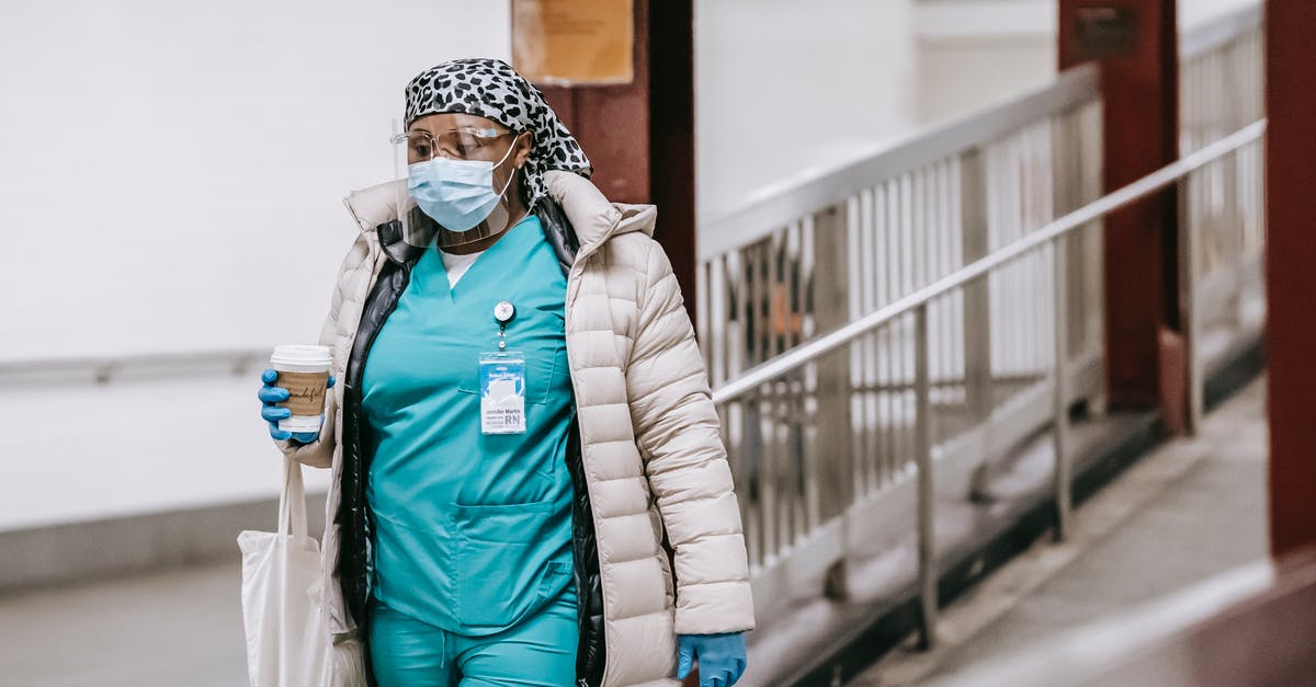 Do I need to go through quarantine at Sydney? - Black female nurse in uniform and protective mask on street