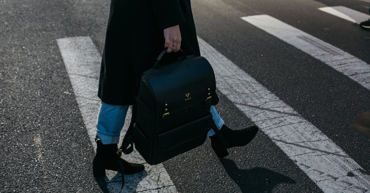 Do I need to have travel insurance when crossing Schengen border? - Person Carrying Bag Walking on Pedestrian Lane