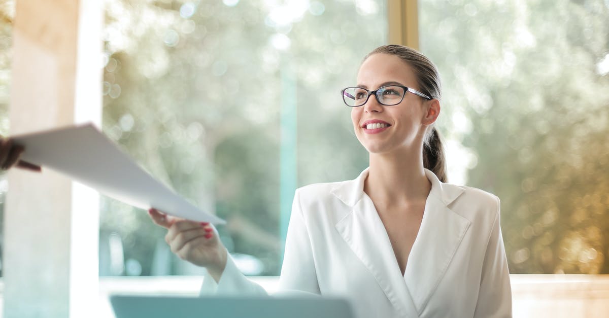 Do I need to pass through emmigration? - Low angle of successful female executive manager in classy style sitting at table with laptop in contemporary workplace and passing documents to colleague