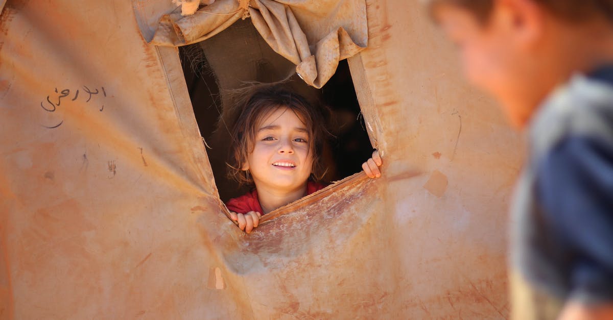 Do I need to physically crop my passport photo? - Smiling little ethnic girl looking out of window in tent